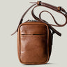 A classic brown leather shoulder bag with a zipper closure and an adjustable strap, made in Italy.