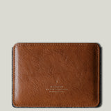 Brown leather passport wallet on a light gray background
