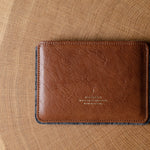 Brown leather passport wallet on a wooden surface