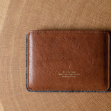 Brown leather passport wallet on a wooden surface