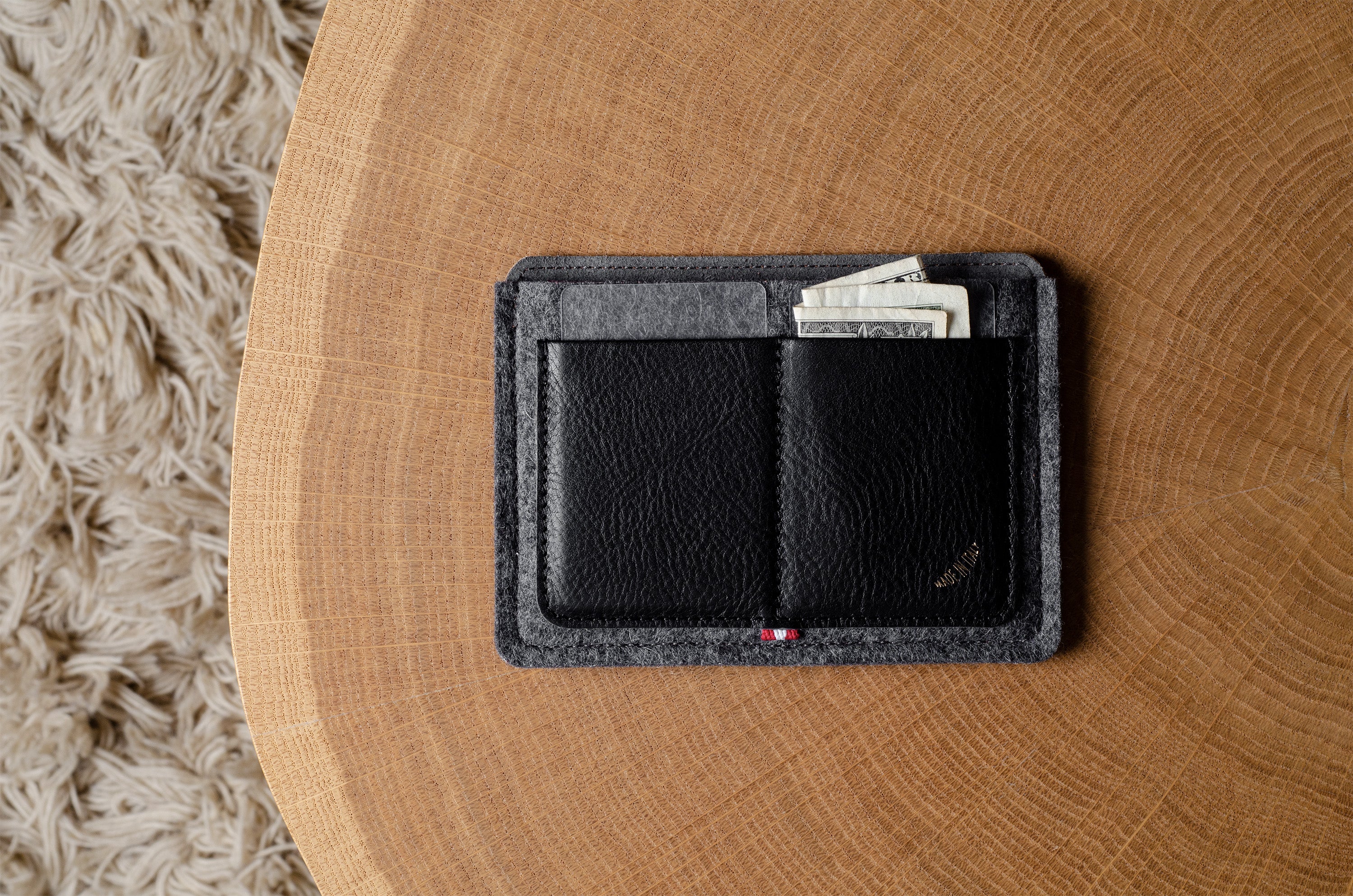 Black wallet with money on a wooden surface