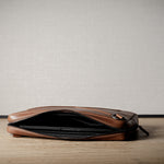 Brown leather bag with X detail and shoulder strap.