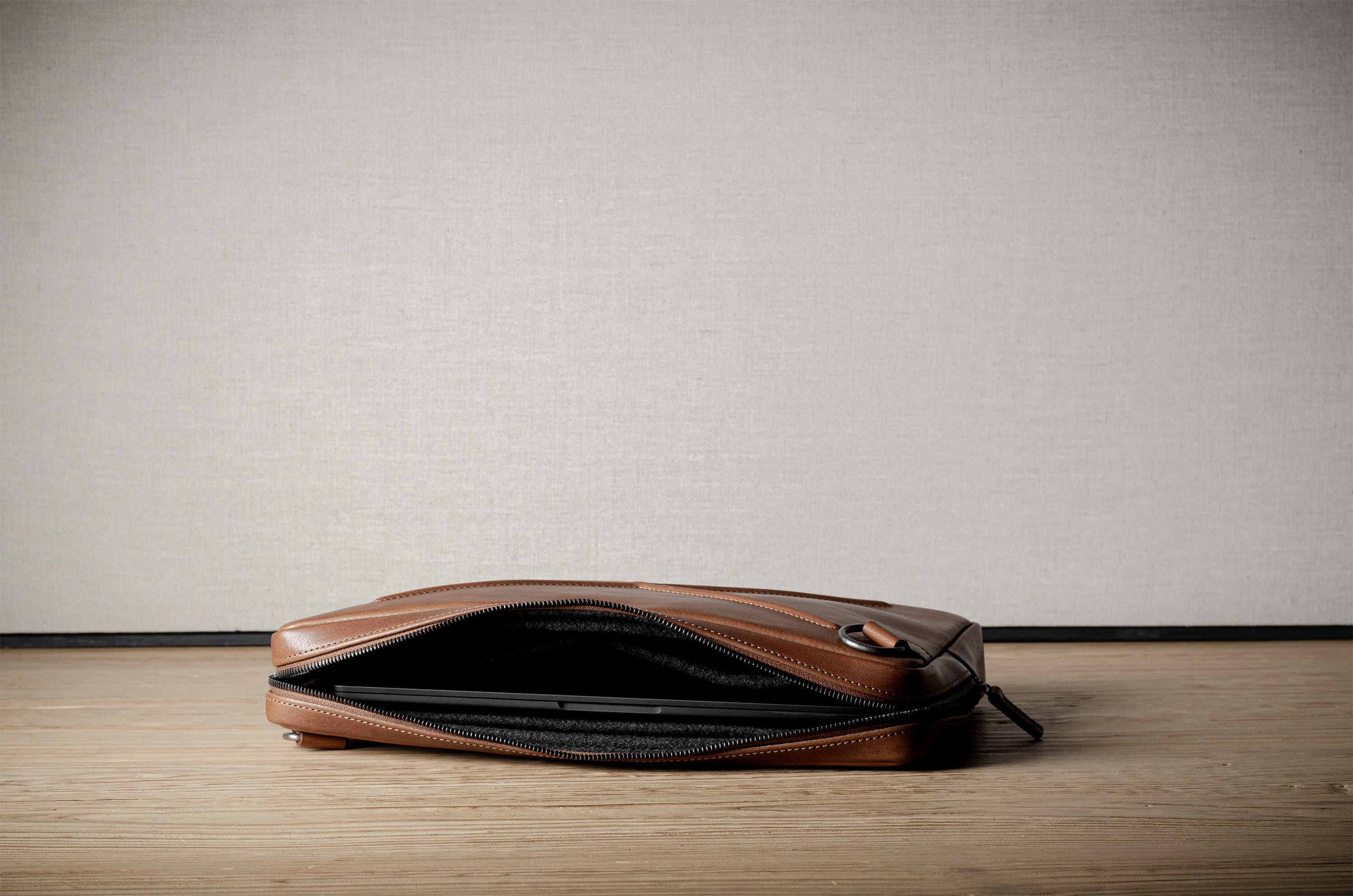 Brown leather bag with X detail and shoulder strap.