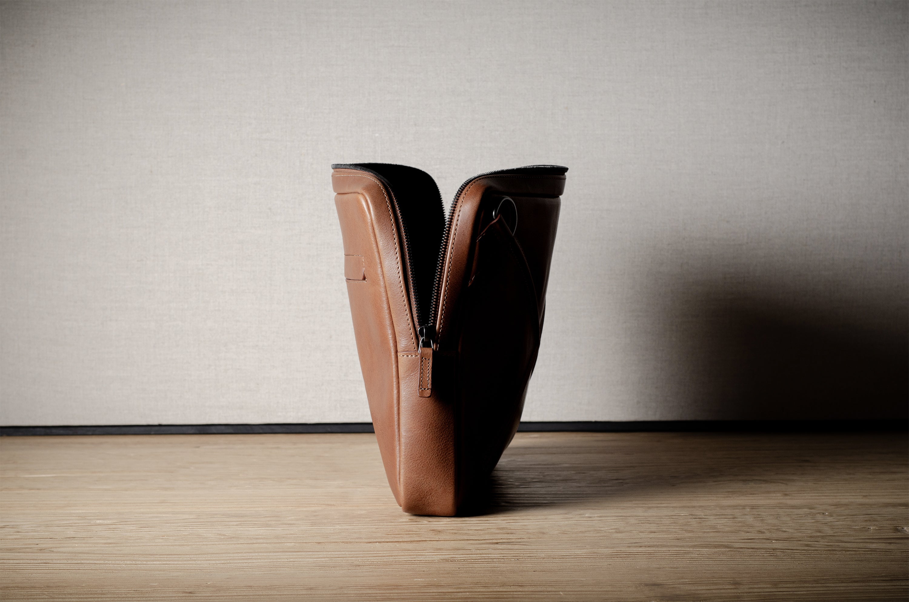 Brown leather bag with X detail and shoulder strap.