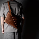 Brown leather bag with X detail and shoulder strap.