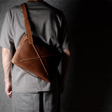 Brown leather bag with X detail and shoulder strap.