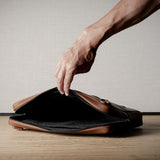 Brown leather bag with X detail and shoulder strap.