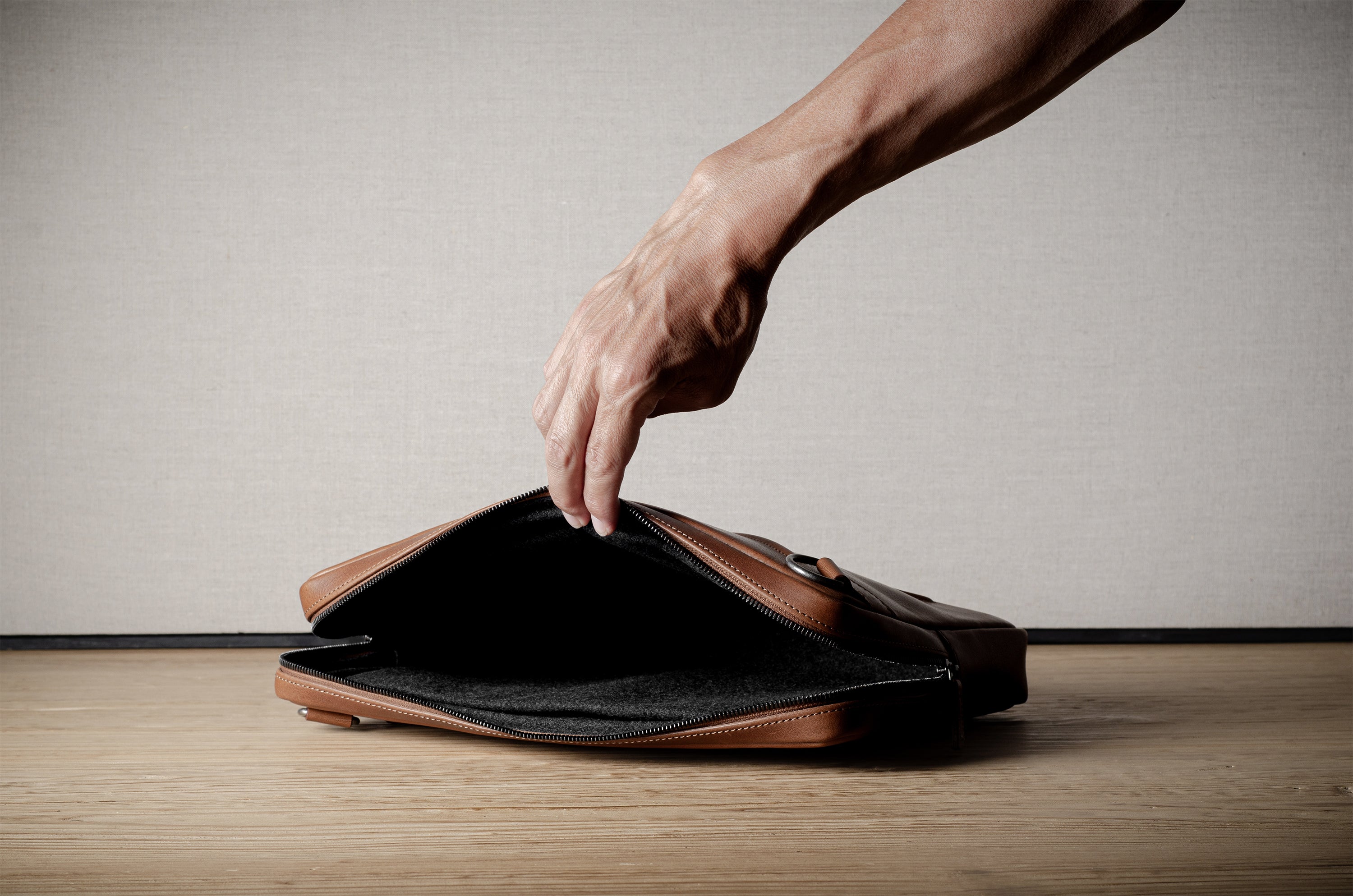 Brown leather bag with X detail and shoulder strap.