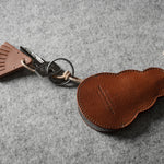 Brown leather keypouch with a leather string on a gray background
