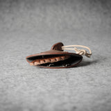 Brown leather keypouch with a leather string on a gray background