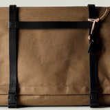 Brown technical fabric messenger bag with black leather straps.