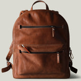 Brown leather backpack on a light gray background