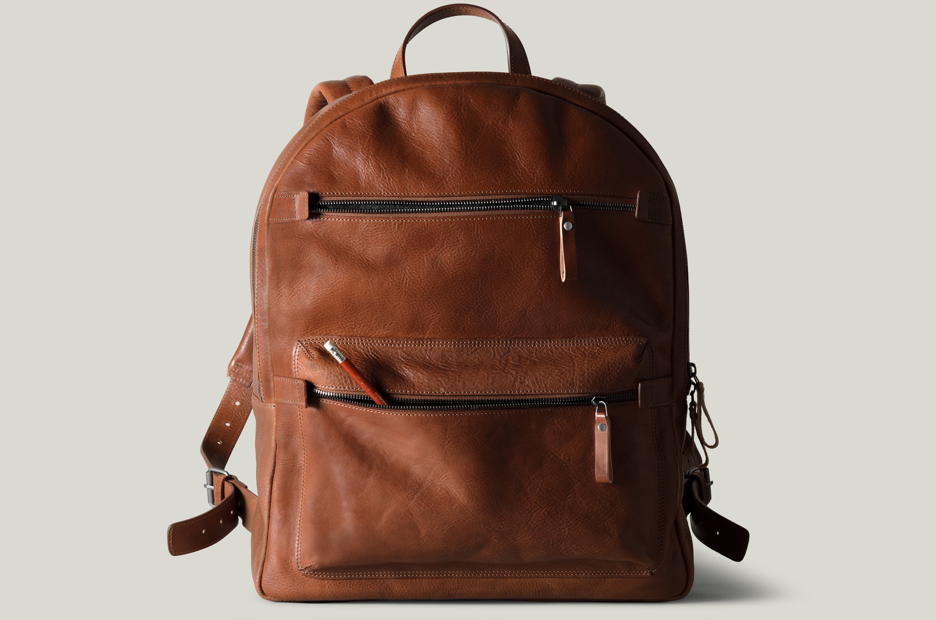 Brown leather backpack on a light gray background