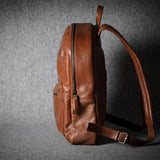 Brown leather backpack on a dark textured background