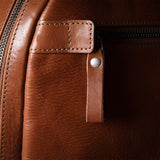 Close-up of a brown leather bag with zipper
