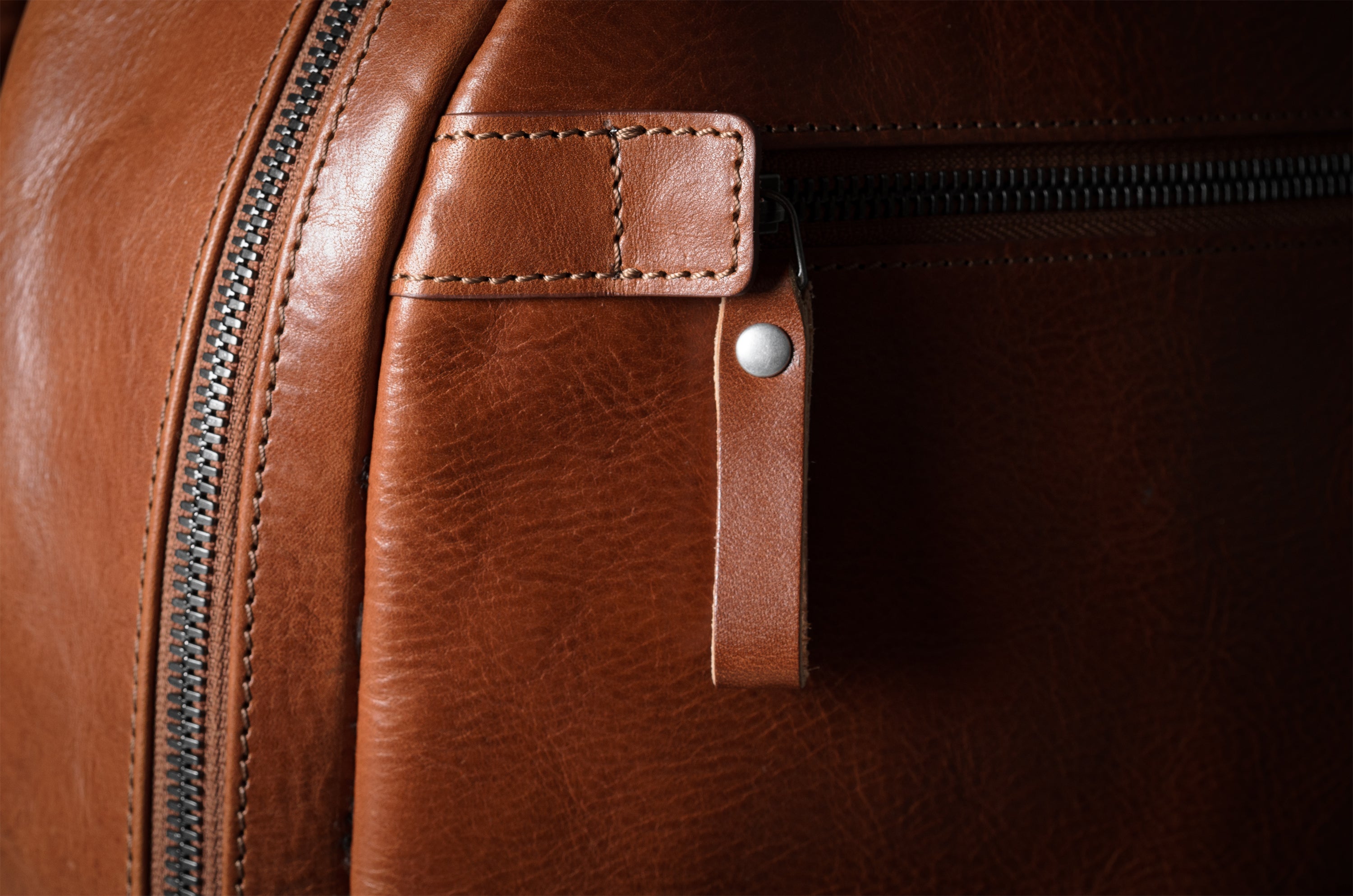 Close-up of a brown leather bag with zipper