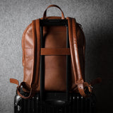 Brown leather backpack on a dark textured background