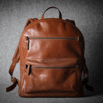 Brown leather backpack on a dark gray background