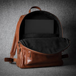 Brown leather backpack on a dark gray background