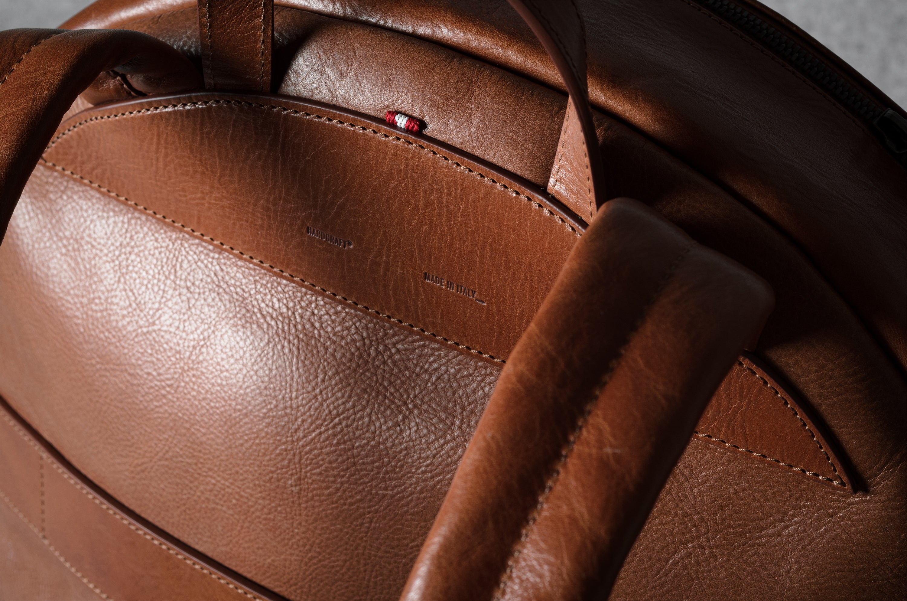 Close-up of a brown leather backpack with visible stitching