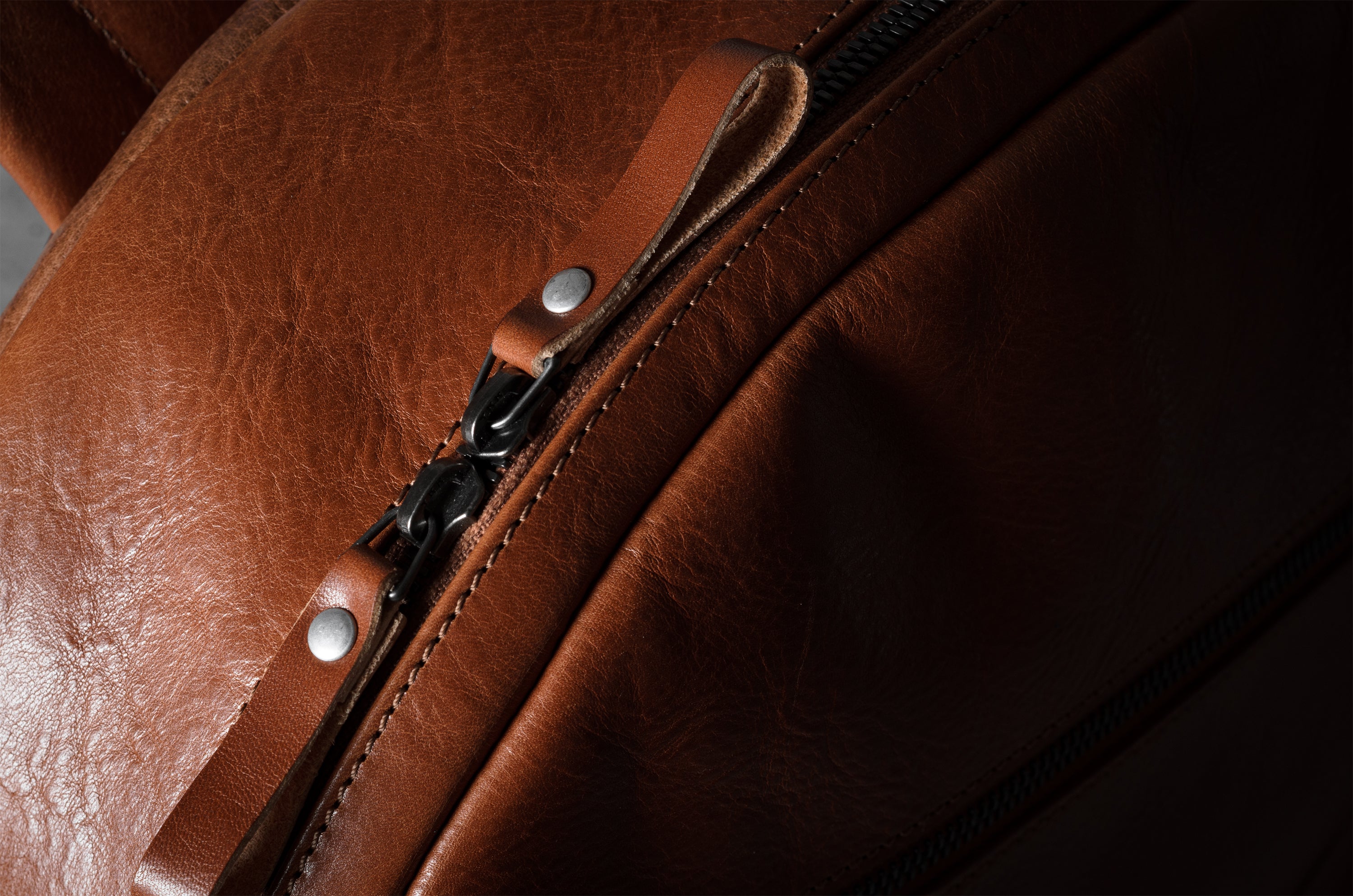 Close-up of a brown leather bag with a zipper