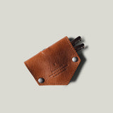 Brown leather key holder with keys on a light gray background