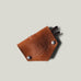Brown leather key holder with keys on a light gray background