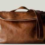 Brown leather shoulder bag with zip opening on white background
