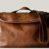 Brown leather shoulder bag with zip opening on white background