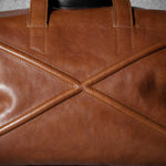 Close-up of a brown leather bag with geometric design