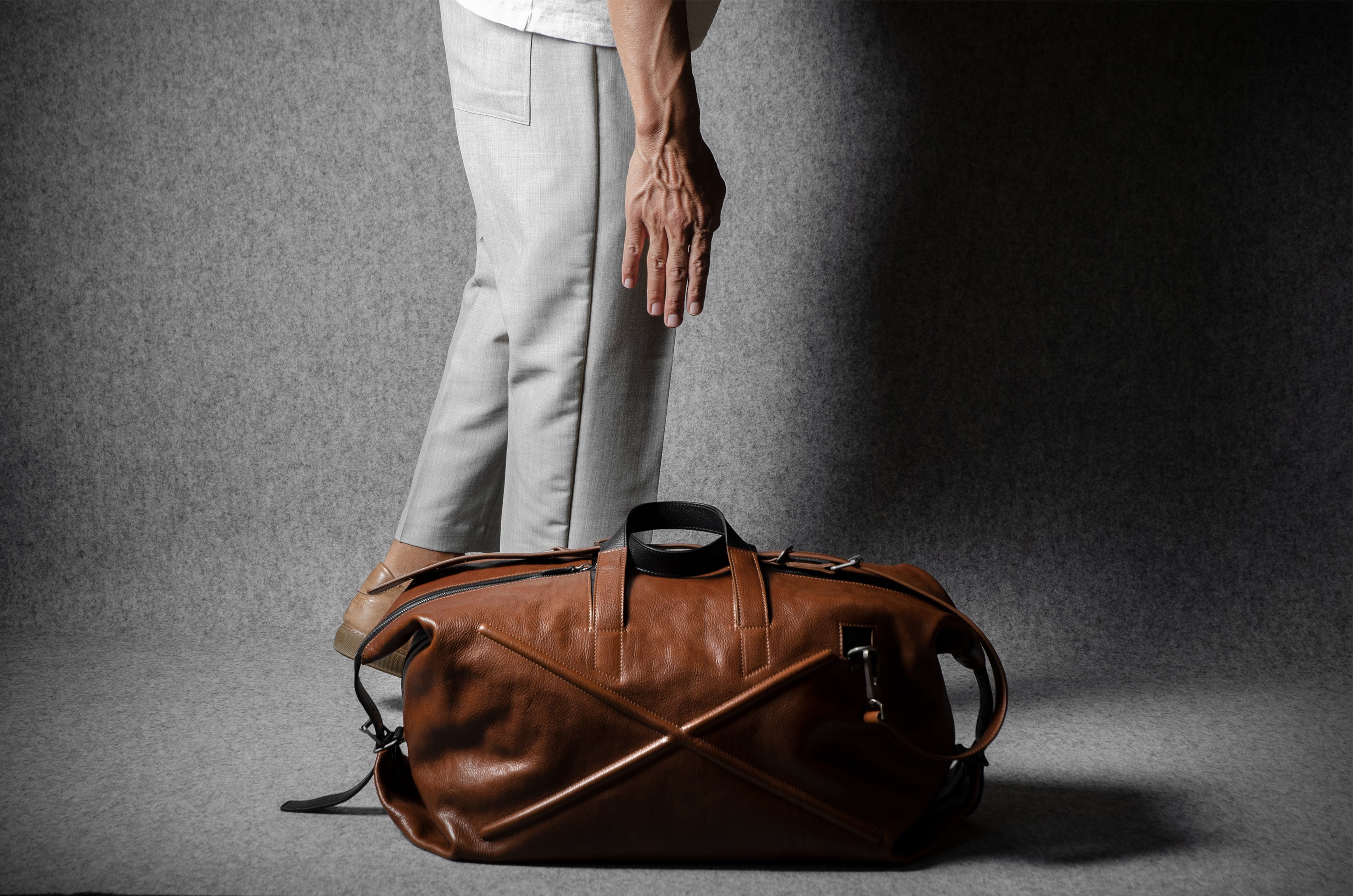 Brown leather duffel bag on a gray background