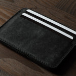 Black cardholder with cards on a wooden surface