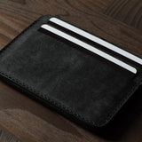 Black cardholder with cards on a wooden surface