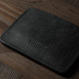 Black leather card case on a wooden surface