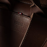 Close-up of a dark brown leather bag showing the interior lining, stitching, and a small red brand tab with white text reading ‘HARDGRAFT MADE IN ITALY'.