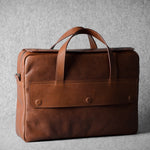 Brown leather briefcase bag on a gray background