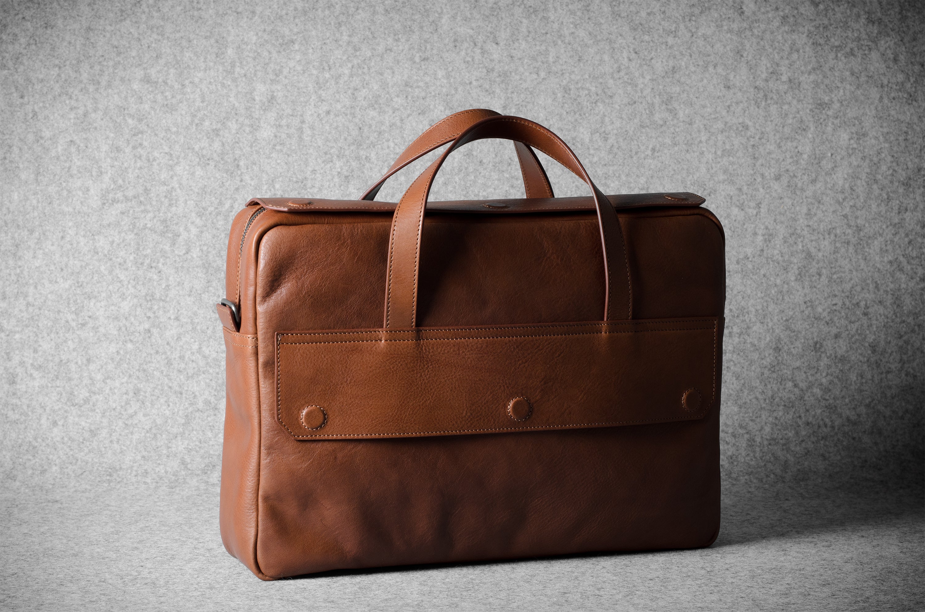 Brown leather briefcase bag on a gray background