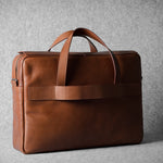 Brown leather briefcase bag on a gray background