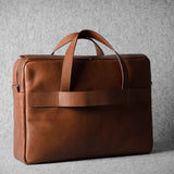 Brown leather briefcase bag on a gray background