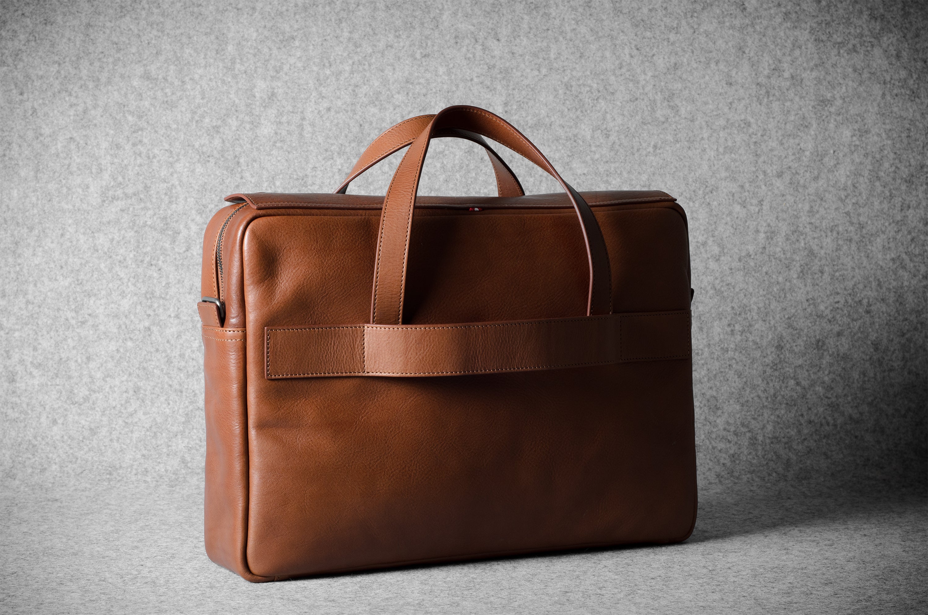 Brown leather briefcase bag on a gray background