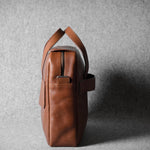 Brown leather briefcase bag on a gray background