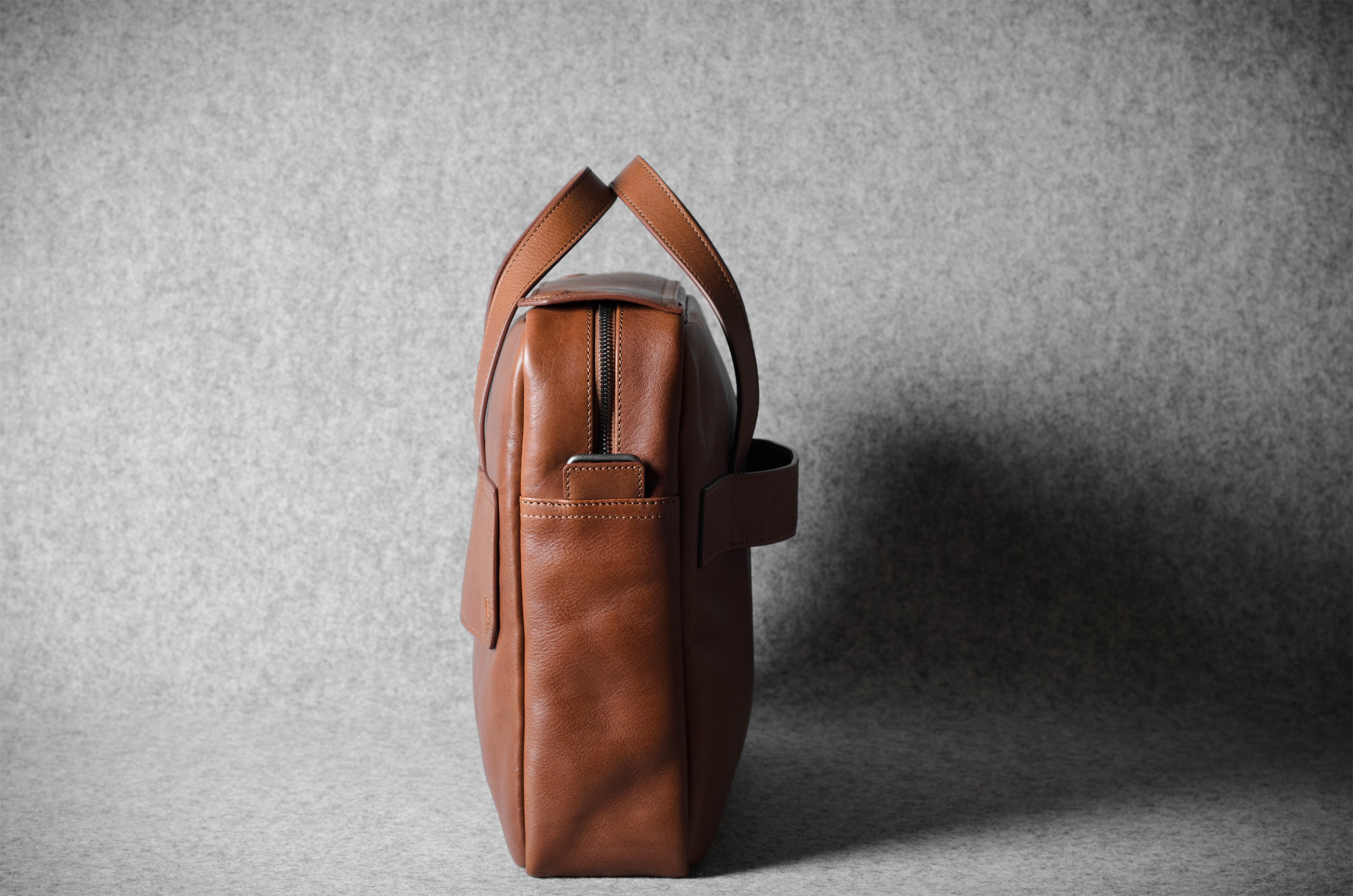 Brown leather briefcase bag on a gray background