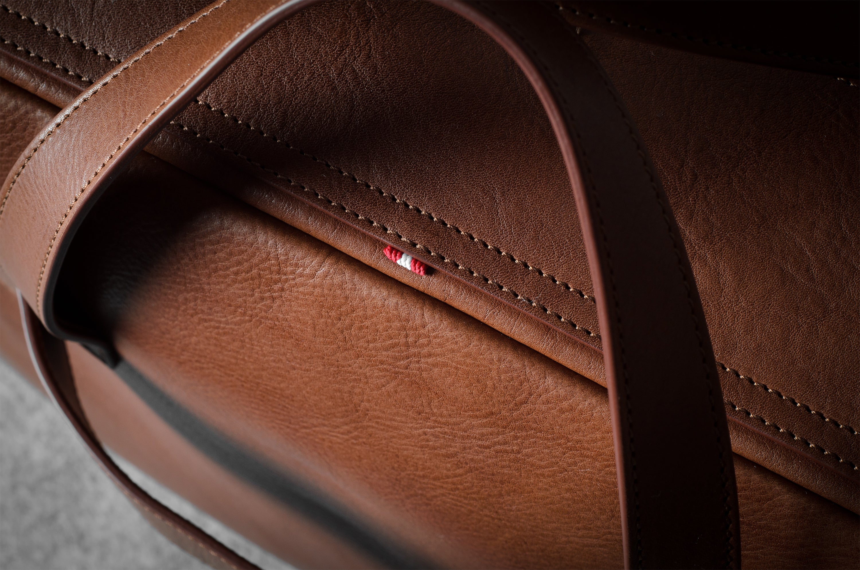 Close-up of a brown leather bag with visible stitching