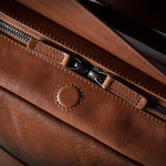 Close-up of a brown leather bag with zipper