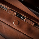 Close-up of a brown leather bag with zipper