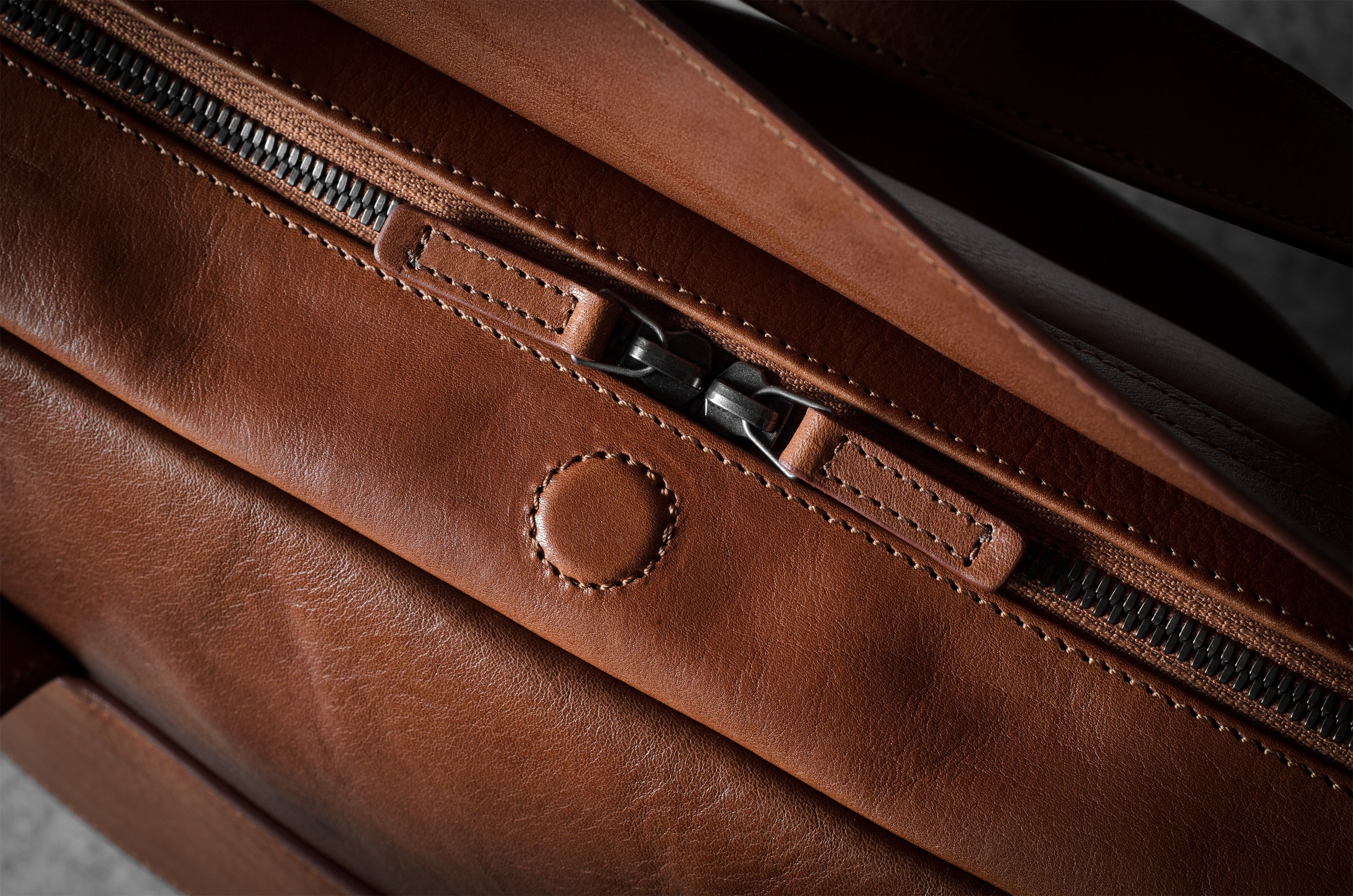 Close-up of a brown leather bag with zipper