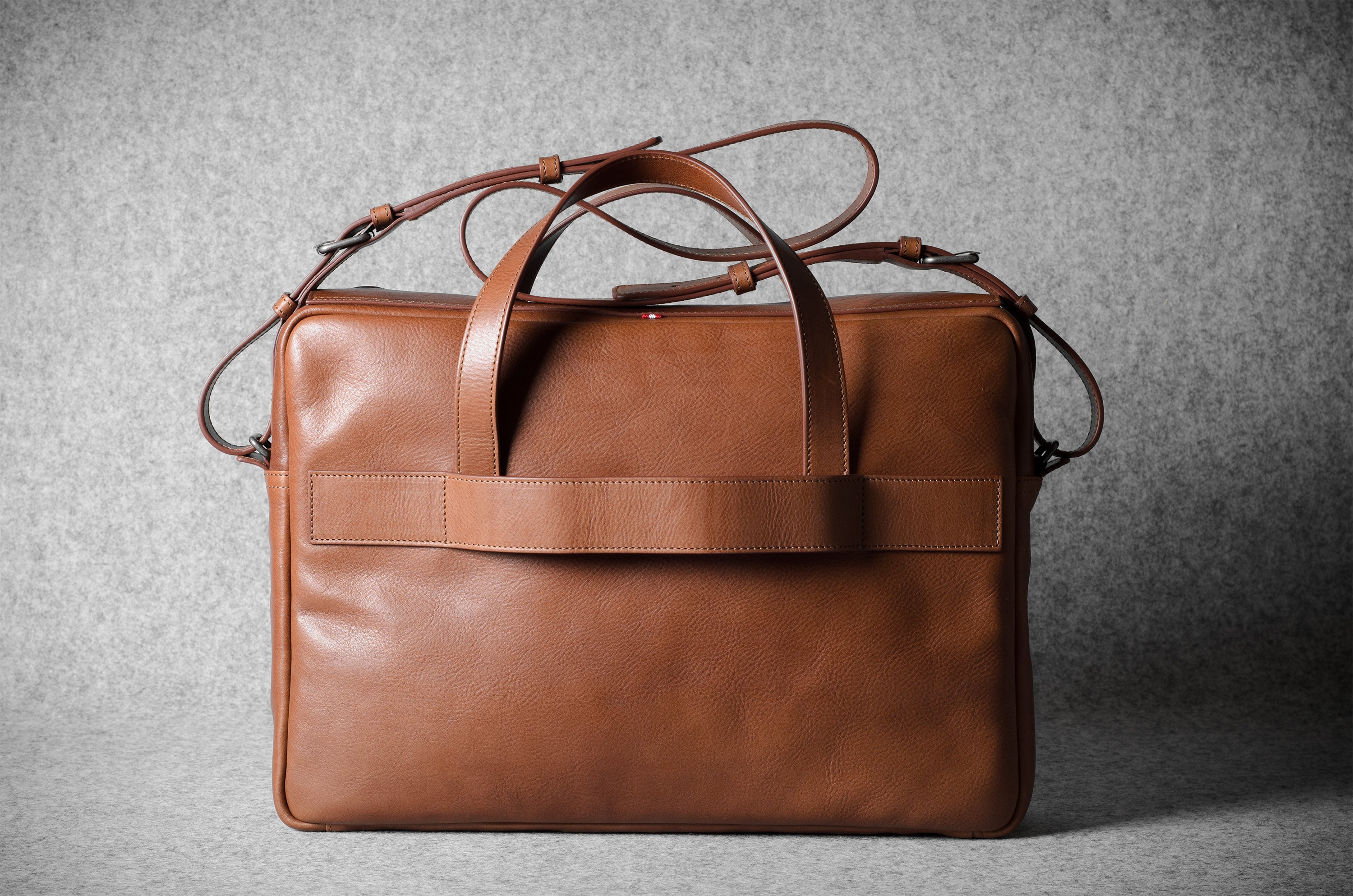 Brown leather briefcase bag on a gray background