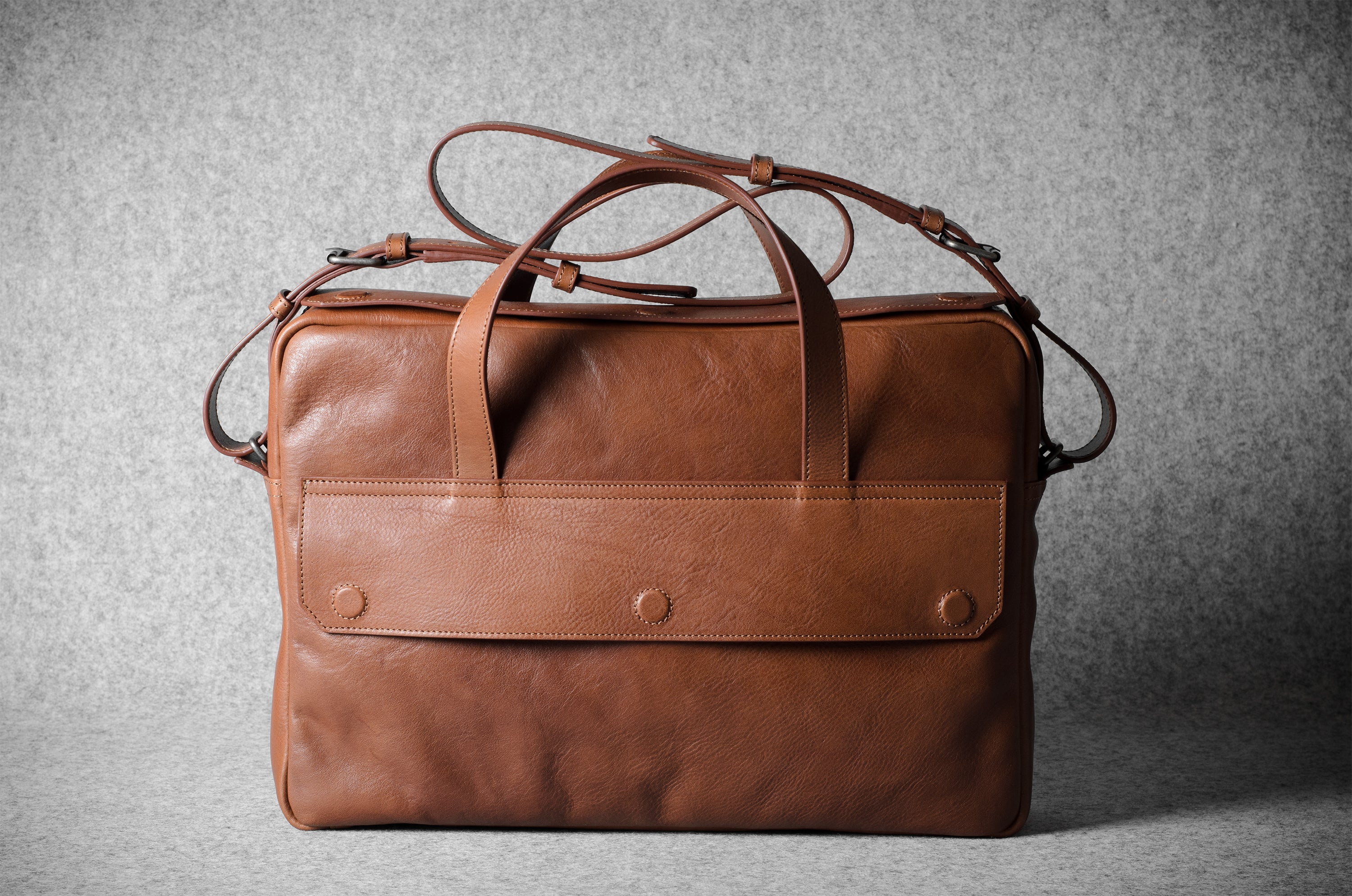 Brown leather briefcase bag on a gray background