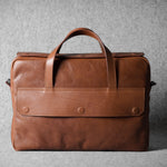 Brown leather briefcase bag on a gray background