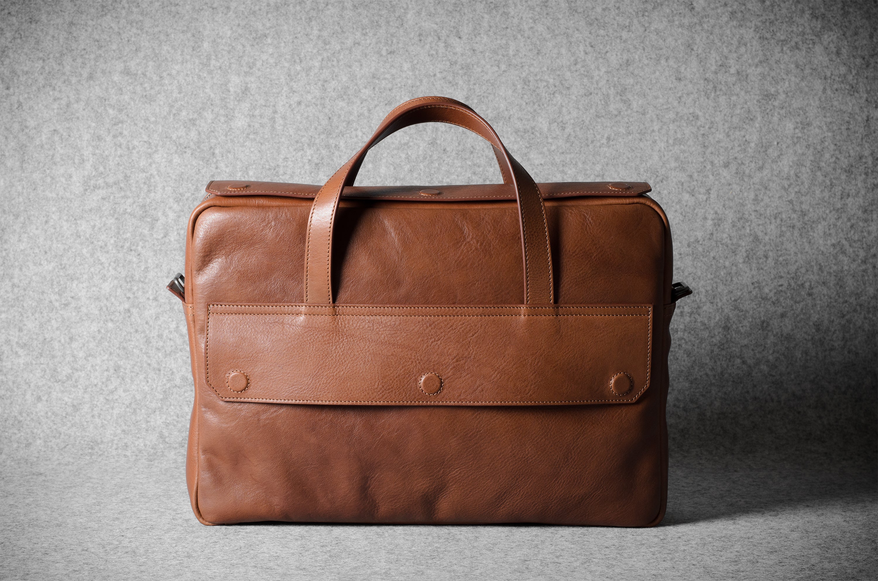 Brown leather briefcase bag on a gray background